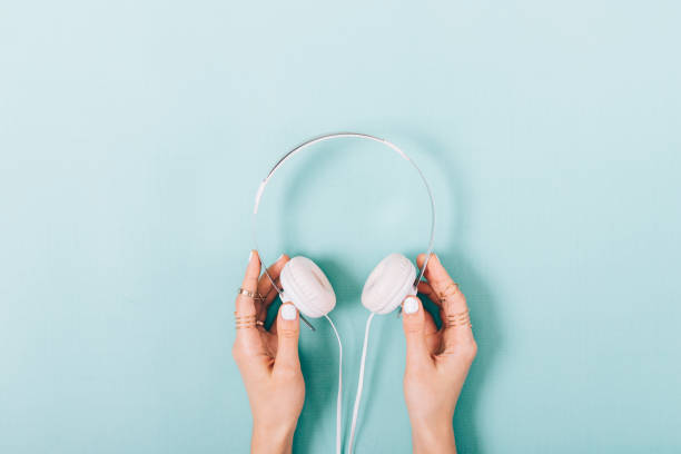 istock White headphones in female hands 915247414
