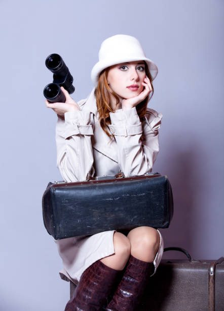istock young redhead girl with suitcase and binocular 915250292
