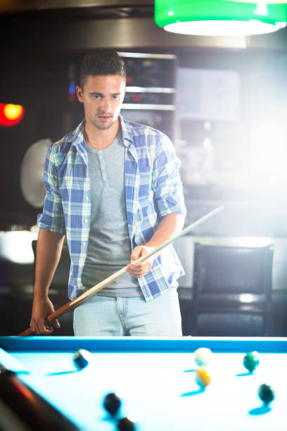 istock Young man standing near pool table 915251000