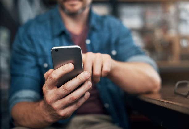Checking in on texts from clients Closeup shot of an unrecognizable designer using a cellphone in an office men hands stock pictures, royalty-free photos & images