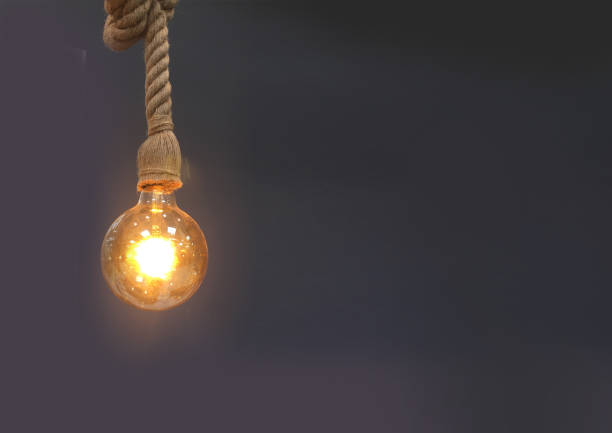 istock Lightbulb hanging in front of dark background 915254330