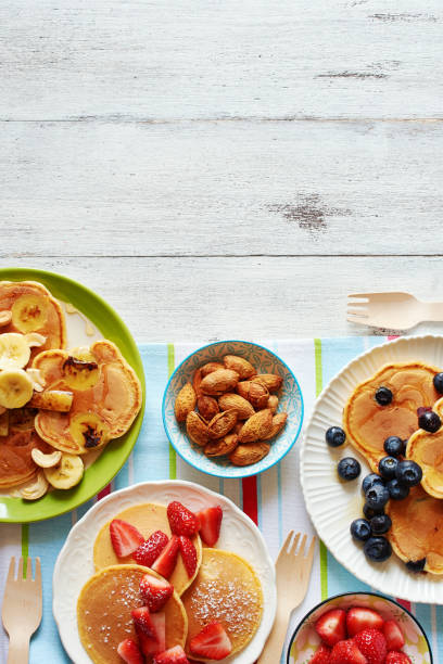 istock Assorted fritters with fresh fruit, berry, nuts and honey on white table with copy space. 915254594