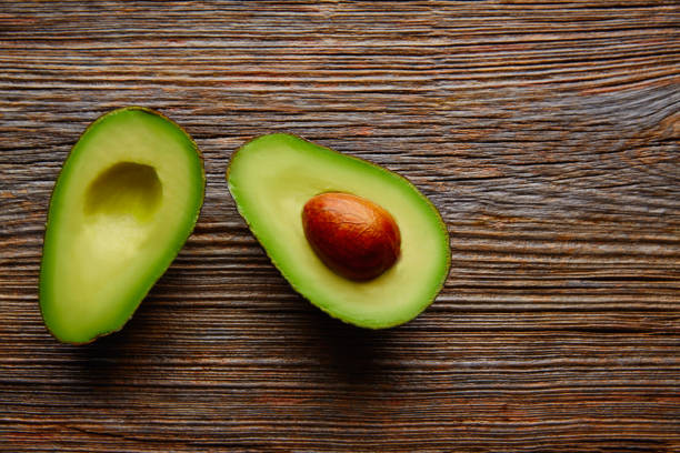 istock avocado cut on aged wood table board 915255472