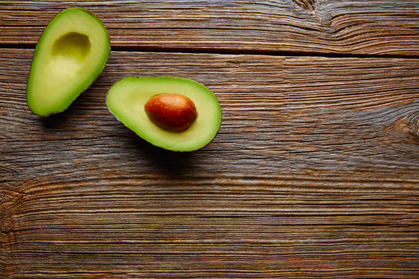 istock avocado cut on aged wood table board 915255728