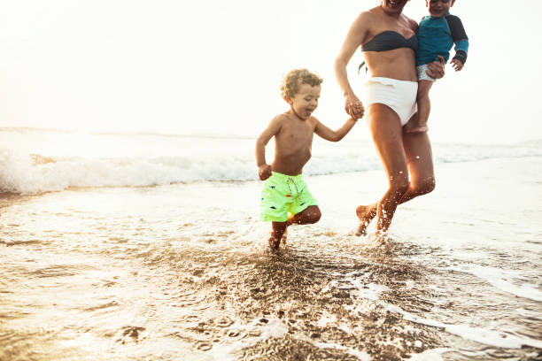istock Mother running with her children on the beach 915255972
