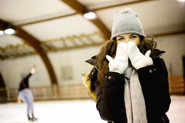 Young and pretty girl skating on indoor ice-rink