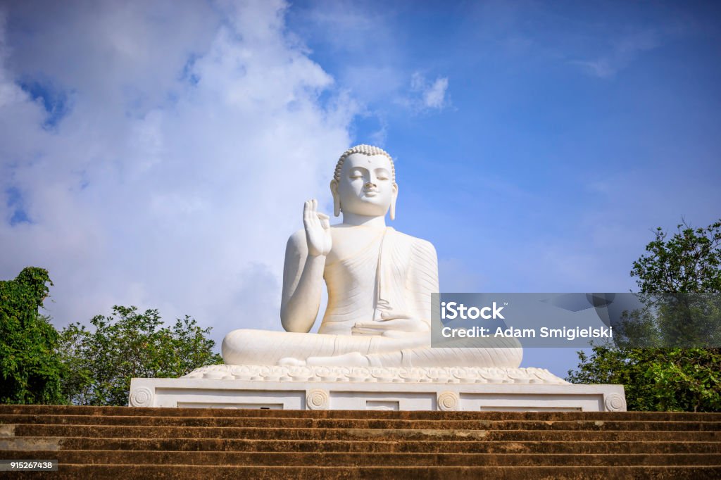 Sitting Buddha at Mihintale The big sculpture of the Sitting Buddha against a blue sky Ancient Stock Photo