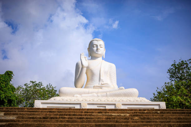 Sitting Buddha at Mihintale The big sculpture of the Sitting Buddha against a blue sky mihintale stock pictures, royalty-free photos & images