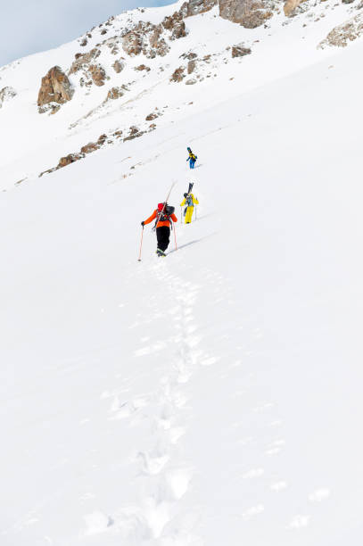 istock two ski freerider climbs the slope into deep snow powder with the equipment on the back fixed on the backpack 915267766