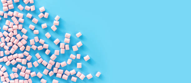 istock Marshmallows on blue background with copyspace. Flat lay or top view. Background or texture of colorful mini marshmallows. Winter food background concept. 915274572