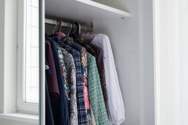 istock women's clothes hanging in open white cabinet 915283584