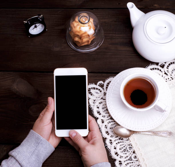 istock two female hands holding a white smartphone with an empty black screen 915283926
