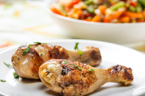 istock Two grilled chicken drumsticks with parsley on palte 915284660