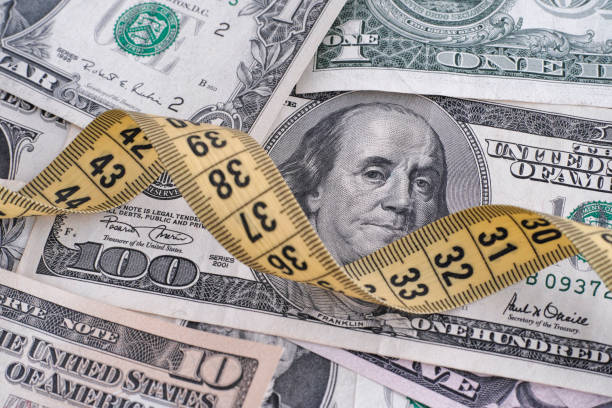 istock Dollar bills and yellow tape measure 915288638