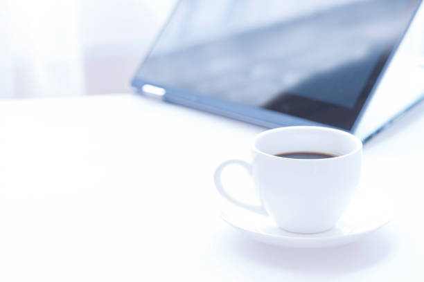 istock Cup of coffee and modern touch screen notebook. 915291050