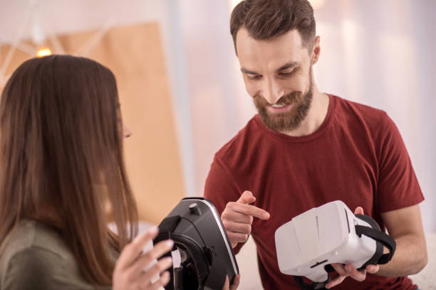 istock Adorable happy couple examining VR headsets 915291174