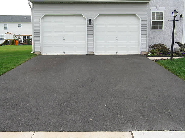 A double garage with white doors at the end of a driveway Driveway in front of house untreated. driveway stock pictures, royalty-free photos & images