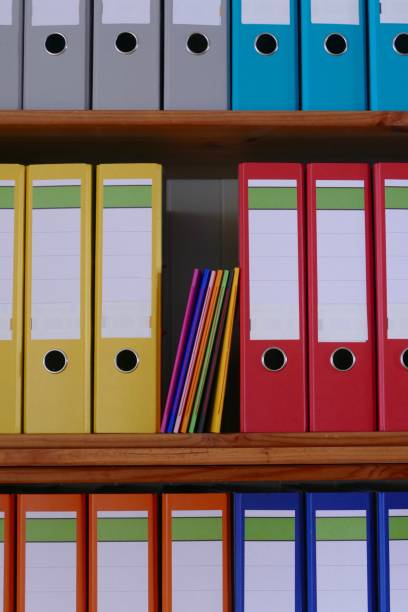 istock Colorful notebooks standing inmidst shelf of ring binders 915296558