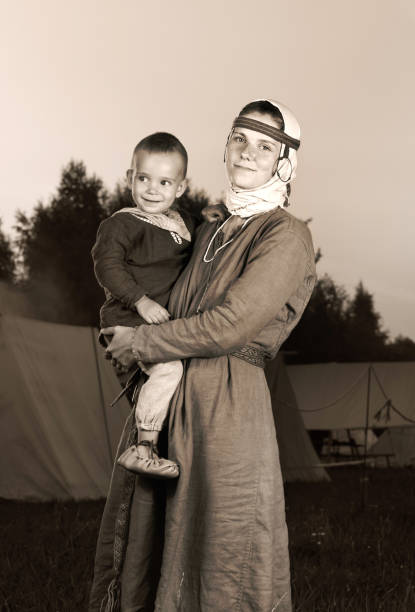 тонированный античный портрет славянки с ребенком в истории костюмов. мать и сын - renaissance period стоковые фото и изображения