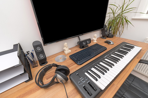 MIDI keyboard and computer on desk for making music