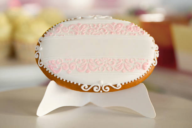 an oval cookie,decorated with glazed pattern on the white stand - raspberry heart shape gelatin dessert valentines day imagens e fotografias de stock