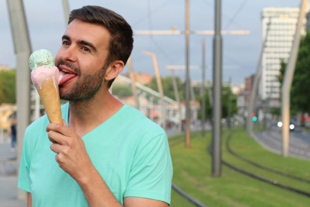 istock Cute male digging an ice cream outdoors 915319238