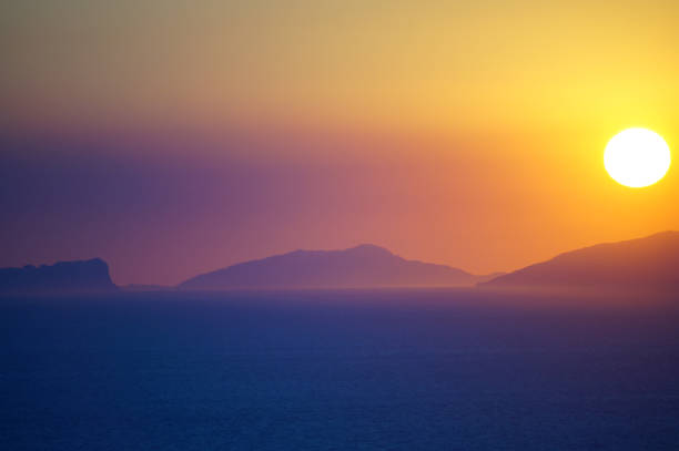 sunset over Capri island, Italy, telephoto shot with glooming colours and sea in the forground