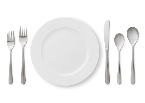 Formal table place setting - plate, forks, spoons and knife isolated on white (excluding the shadow)