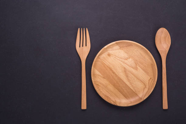 Top view bright empty wooden dish/bowl on black stone board background