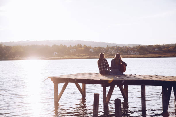 istock Friends playing guitar on pier 915324400