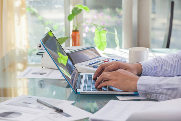 Business man typing on laptop keyboard during working at home stock photo