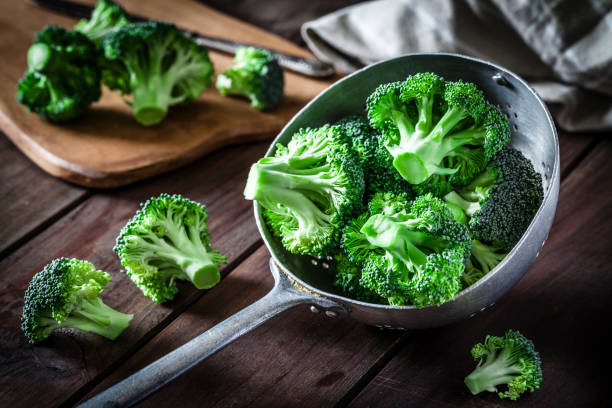 Broccoli in an old metal colander Fresh organic broccoli in an old metal colander shot on rustic wooden table. This vegetable is considered a healthy salad ingredient. Predominant colors are green and brown. Low key DSRL studio photo taken with Canon EOS 5D Mk II and Canon EF 100mm f/2.8L Macro IS USM healthy eating color image horizontal nobody stock pictures, royalty-free photos & images