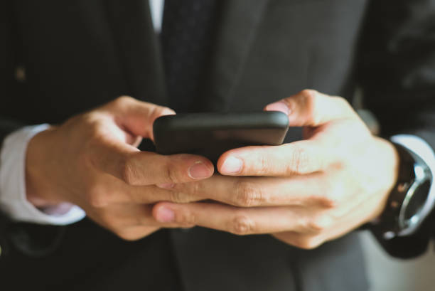 istock businessman holding smartphone & using app. man texting message outdoors. social network communication, wireless connection, lifestyle concept 915332328