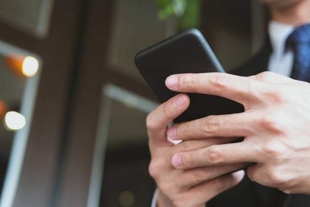 istock businessman holding smartphone & using app. man texting message outdoors. social network communication, wireless connection, lifestyle concept 915332336