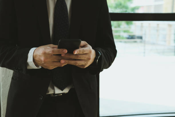 istock businessman holding smartphone & using app at office. man texting message at workplace. social network communication, wireless connection, lifestyle concept 915332416