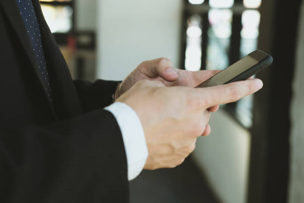 istock businessman holding smartphone & using app at office. man texting message at workplace. social network communication, wireless connection, lifestyle concept 915332454