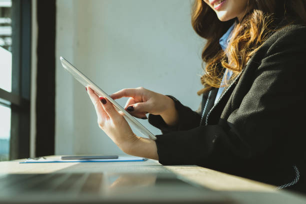 istock businesswoman using tablet computer at workplace. startup woman working with computer at office.  young female entrepreneur analyze accounting market data. 915332636