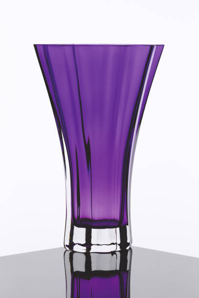 Decorative glass vase with artificial flowers on black background.