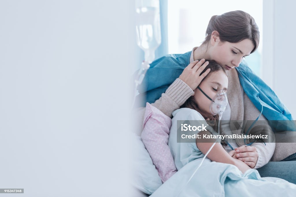 Child using an oxygen mask Older sister and child in the hospital breathing using an oxygen mask Child Stock Photo