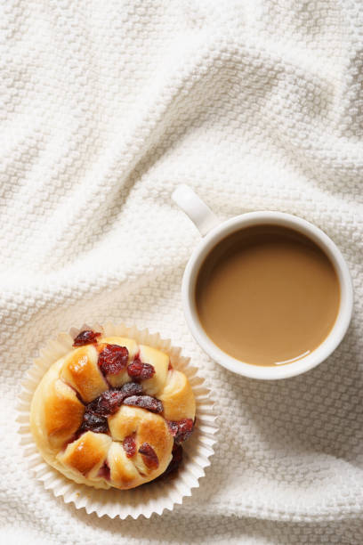 bed breakfast with coffee cup and sweet bread on white blanket