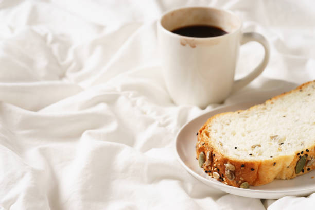 istock coffee cup and bread in bed, cozy breakfast 915348820