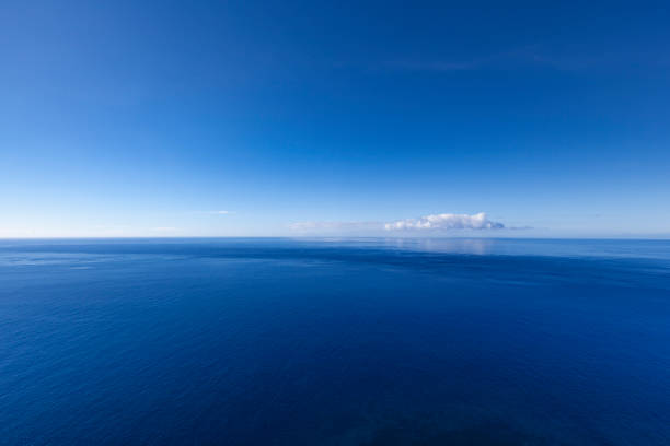 nel blu, oceano paesaggio marino con nuvola solitaria - horizon over water horizontal surface level viewpoint foto e immagini stock