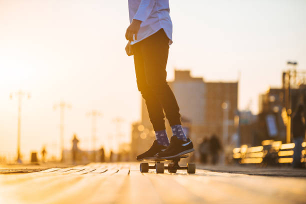 istock Young man riding longboard on the bordwalk, feet only 915352308