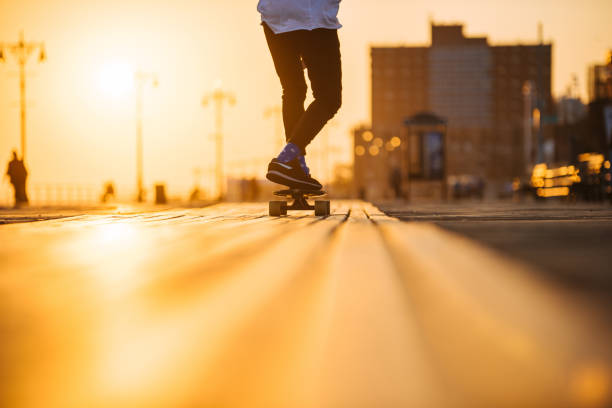 Young man riding longboard on the bordwalk, feet only stock photo