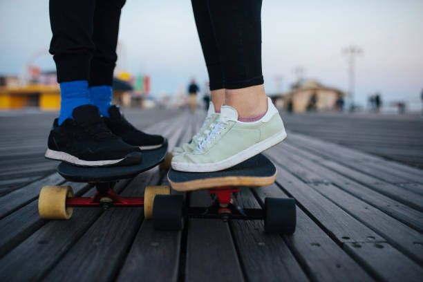 istock Youngsters on the longboards on boardwalk, riding together 915352402