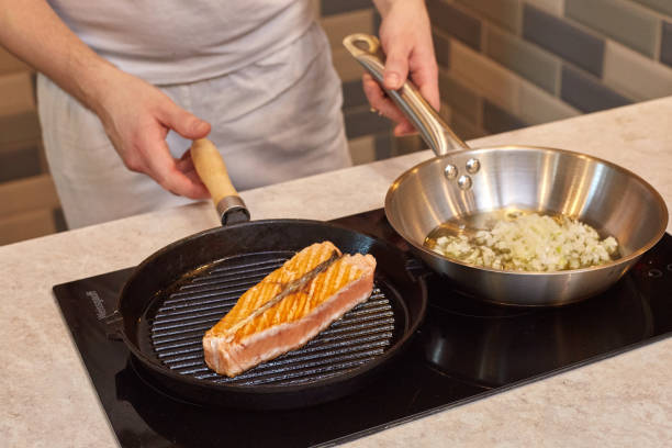 istock Man preparing salmon on the grill pan 915361386