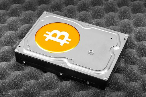 Computer hard drive with Bitcoin cryptocurrency logo on it, illustrating the concept of the Bitcoin wallet.