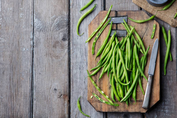 istock Green beans on wooden cutting board. Top view 915372348