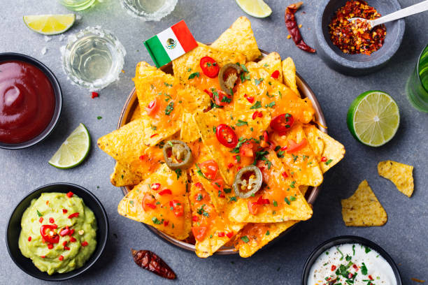 nachos chips com bandeira mexicana e mergulha a variedade na bacia preta. fundo de pedra cinza. vista superior - chili pepper guacamole food beer - fotografias e filmes do acervo