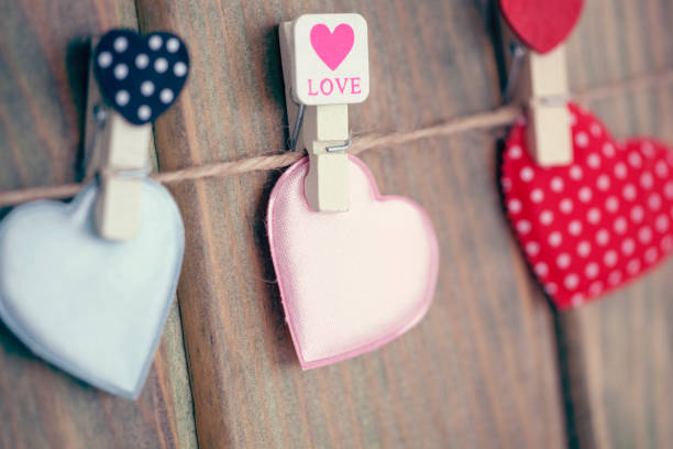 istock Lovely hearts hanging on wooden background. 915376834